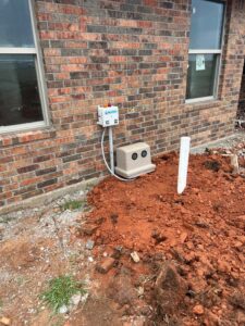 A NuWater aerobic septic system installed for a new home in Arcadia Oklahoma by Cyclone Septics with the control panel mounted on the house