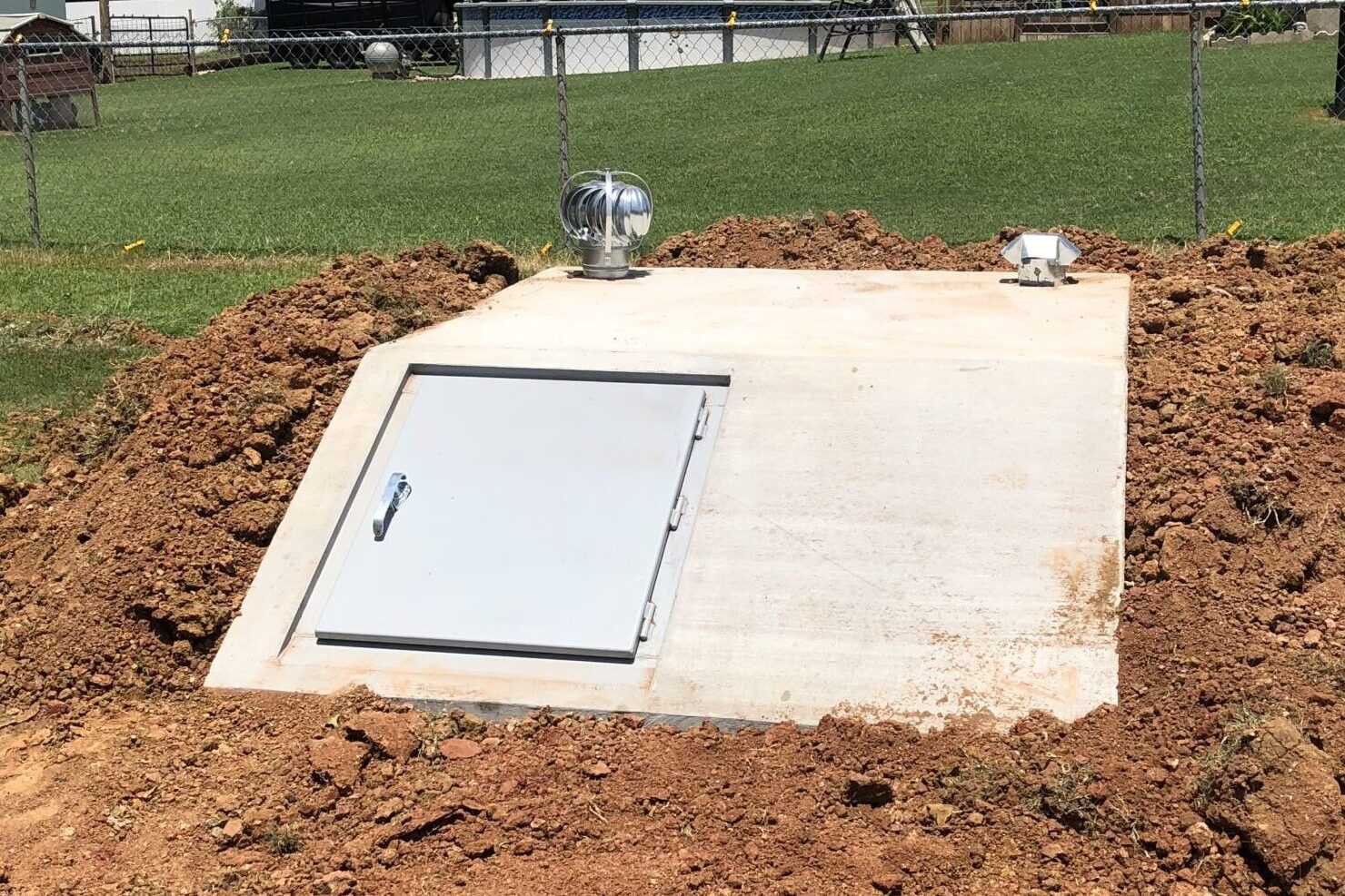 Newly installed above-ground storm shelter at a residential property in Edmond, Oklahoma