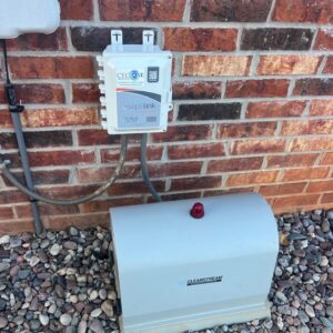 Septilink septic monitoring system installed next to aerobic control panel on residential home in Edmond, OK