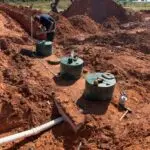 Aerobic Septic System Installation in Edmond, OK | Cyclone Septic & Plumbing Aerobic septic system components being installed in red Oklahoma soil near Edmond