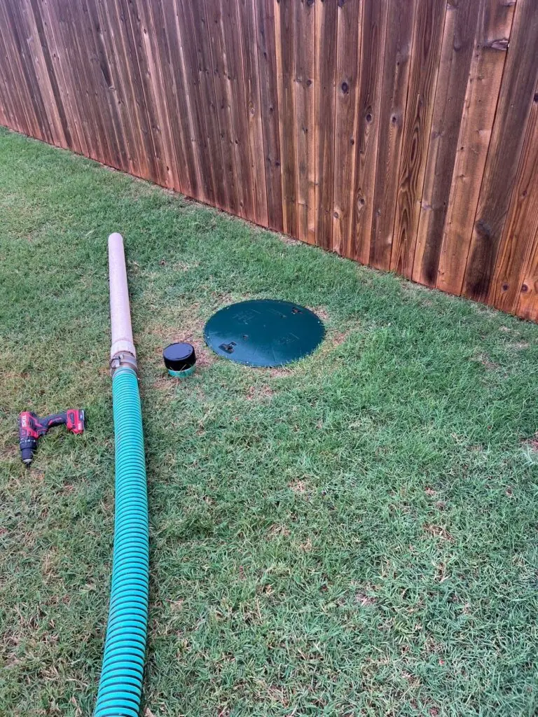 Septic pumping hose connected to a tank access riser in Piedmont, Oklahoma