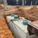 Septic Tank Installation - Jones, Oklahoma | Cyclone Septic & Plumbing Precast concrete septic tank being lowered into a trench during installation on a Jones, OK property
