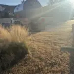 Septic Pumping Service - Jones, Oklahoma | Cyclone Septic & Plumbing Large silver tanker truck parked on a quiet residential street with dry brown grass and sun glare in the foreground