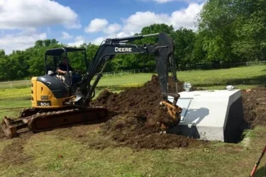 Excavator installing a concrete storm shelter in Oklahoma yard