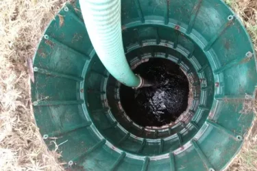 Septic tank being pumped through an access riser in Oklahoma City, Oklahoma