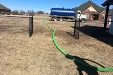 Cyclone vacuum truck pumping a residential septic tank in Guthrie, Oklahoma