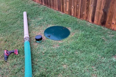 Septic pumping hose connected to a tank access riser in Piedmont, Oklahoma