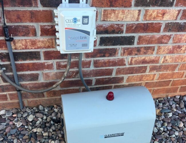 Septilink septic monitoring system installed next to aerobic control panel on residential home in Edmond, OK